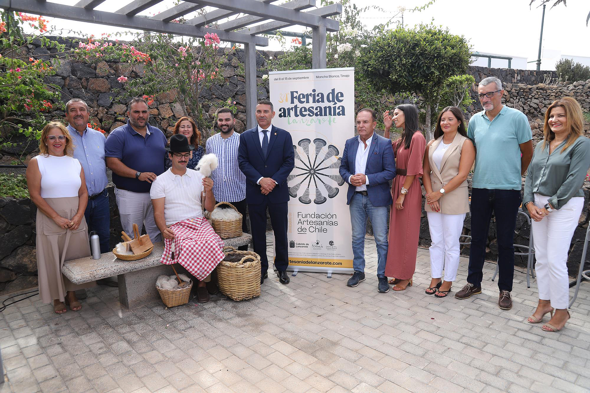 Inauguración Feria de Artesanía de Lanzarote 2025 Inauguración oficial de la Feria de Artesanía de Lanzarote 2025 en Mancha Blanca con autoridades y artesanos frente al cartel.