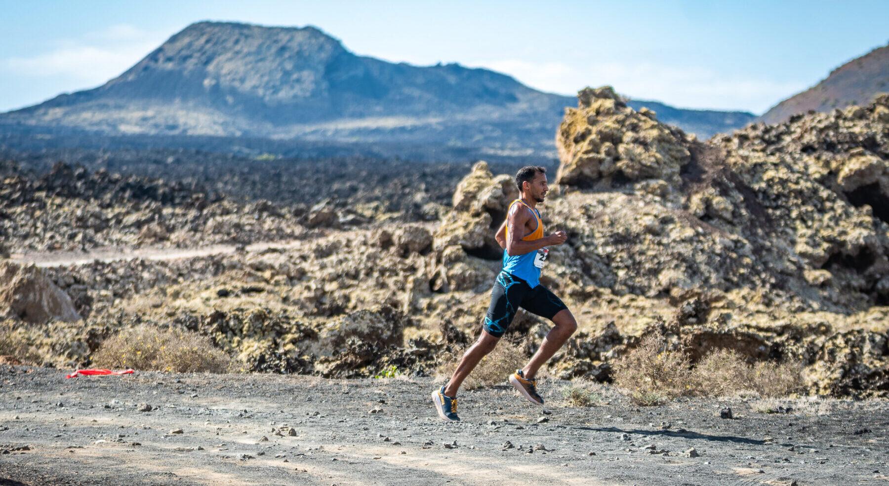 Runners in Famara Total 2025 with the Risco de Famara in the background