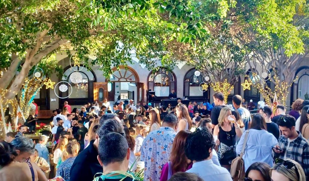 Multitud en ambiente festivo bajo los árboles con luces en Costa Teguise durante las Fiestas 2025