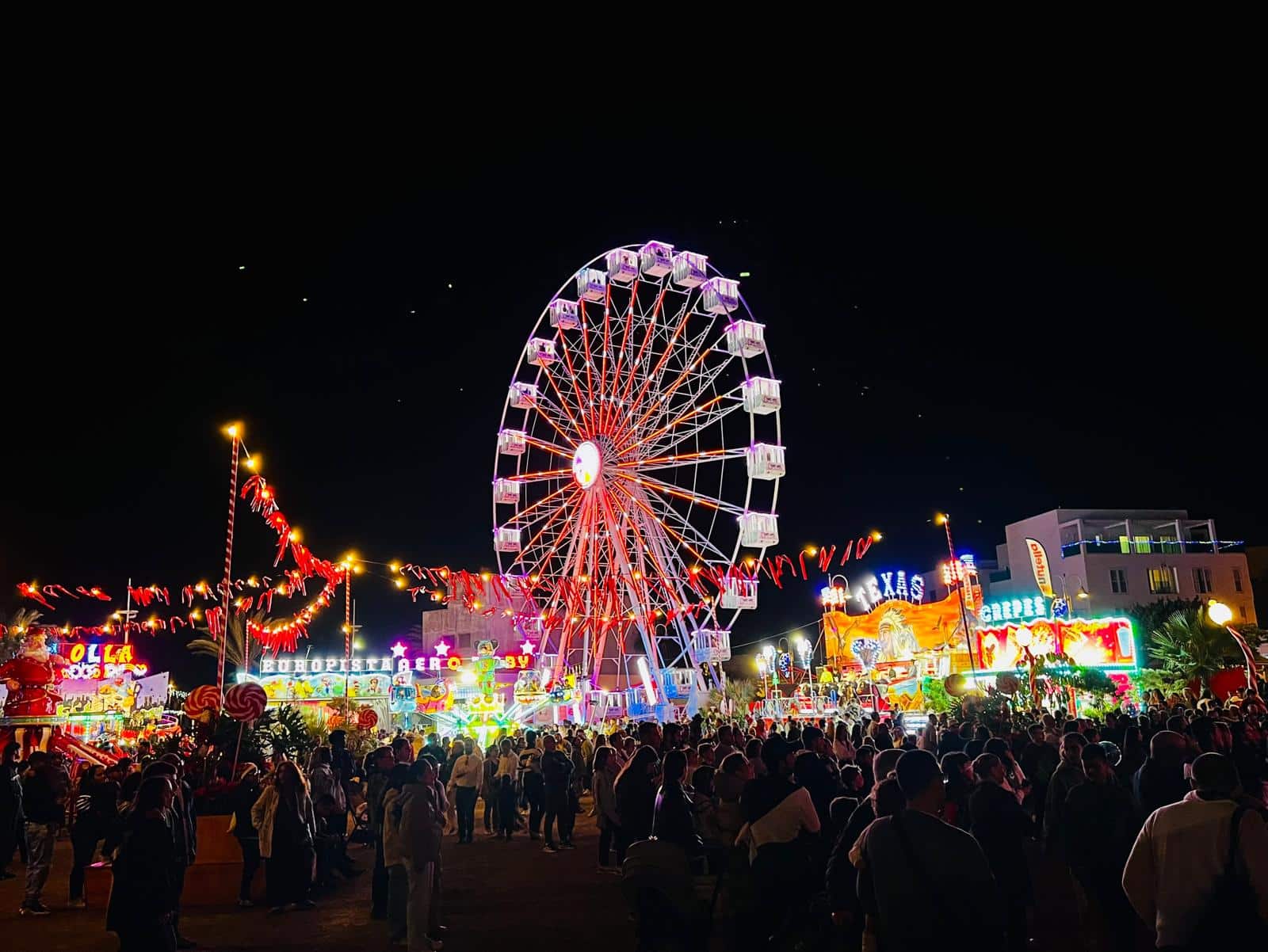 Noria iluminada y atracciones en la feria Navilan Arrecife 2025–2026