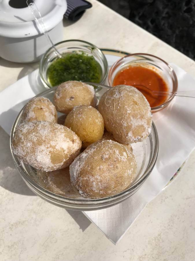 Plato de papas arrugadas canarias con mojo rojo y mojo verde al fondo, comida tradicional de Lanzarote